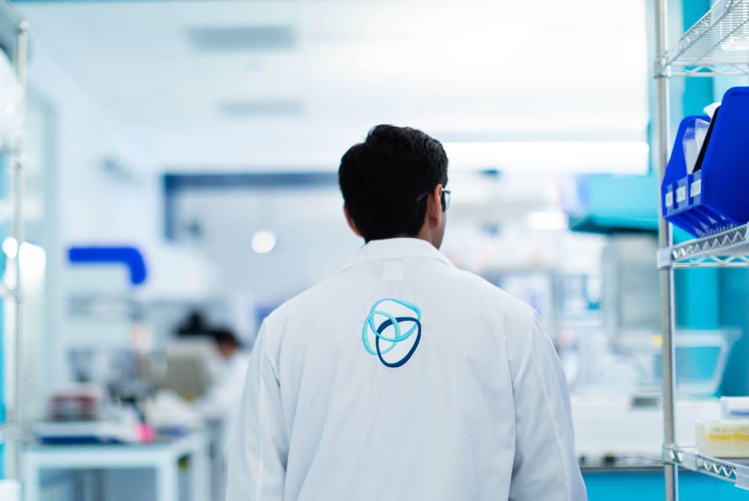 A BlueRock Therapeutics scientist wearing a lab coat with the BlueRock logo visible