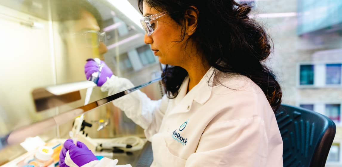 A BlueRock Therapeutics scientist in goggles and a lab coat working in a lab