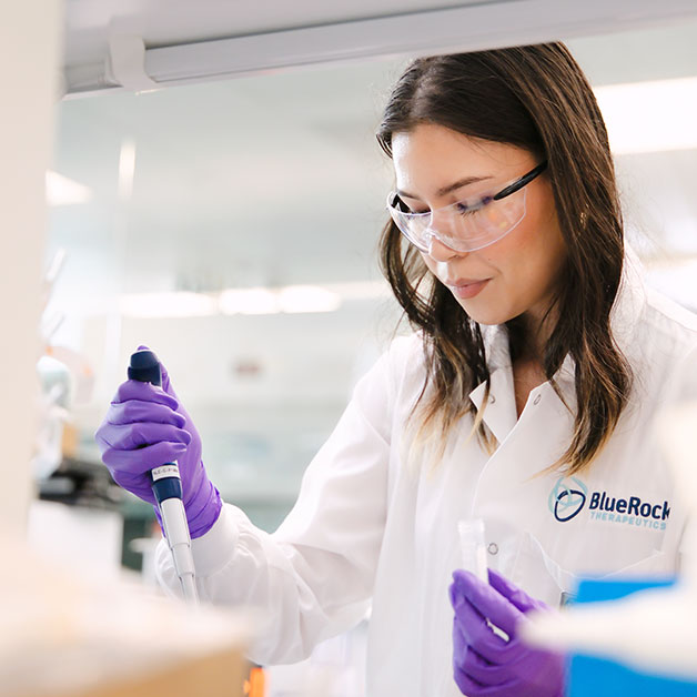 Woman scientist in goggles and gloves pipetting